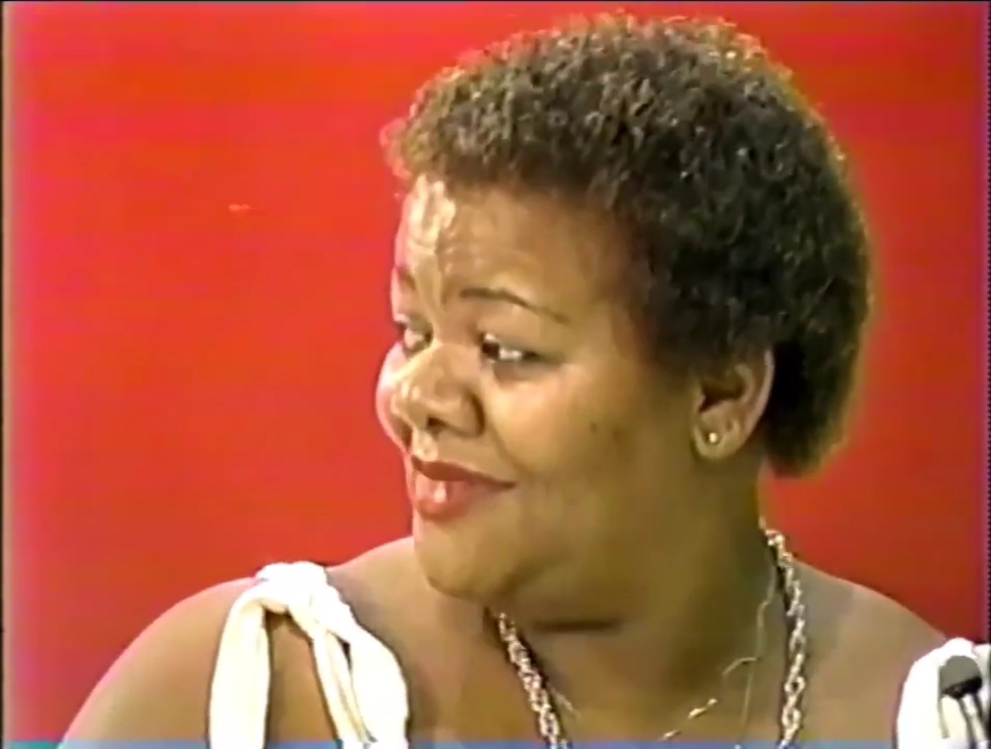 Close-up of a smiling contestant on The Price is Right, with a red background.