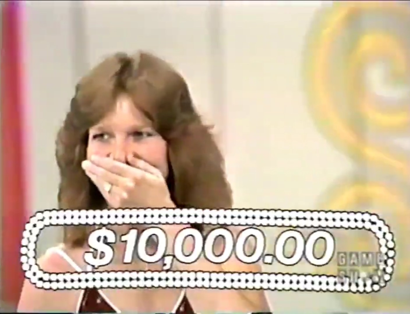 ,000 prize reveal moment during a game show, with a contestant covering her mouth in shock.