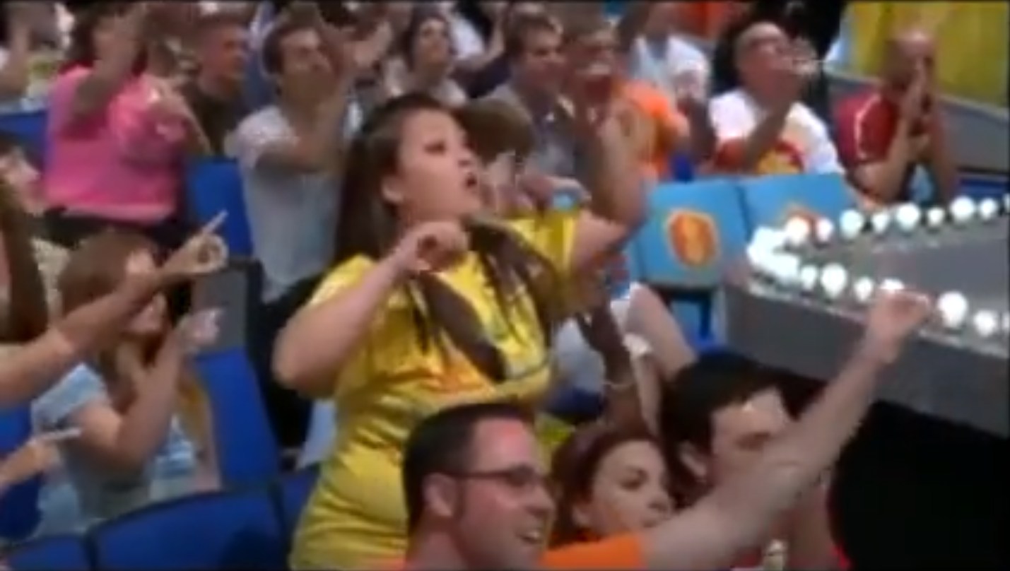 Audience members enthusiastically cheer and participate during a game segment on a television show.