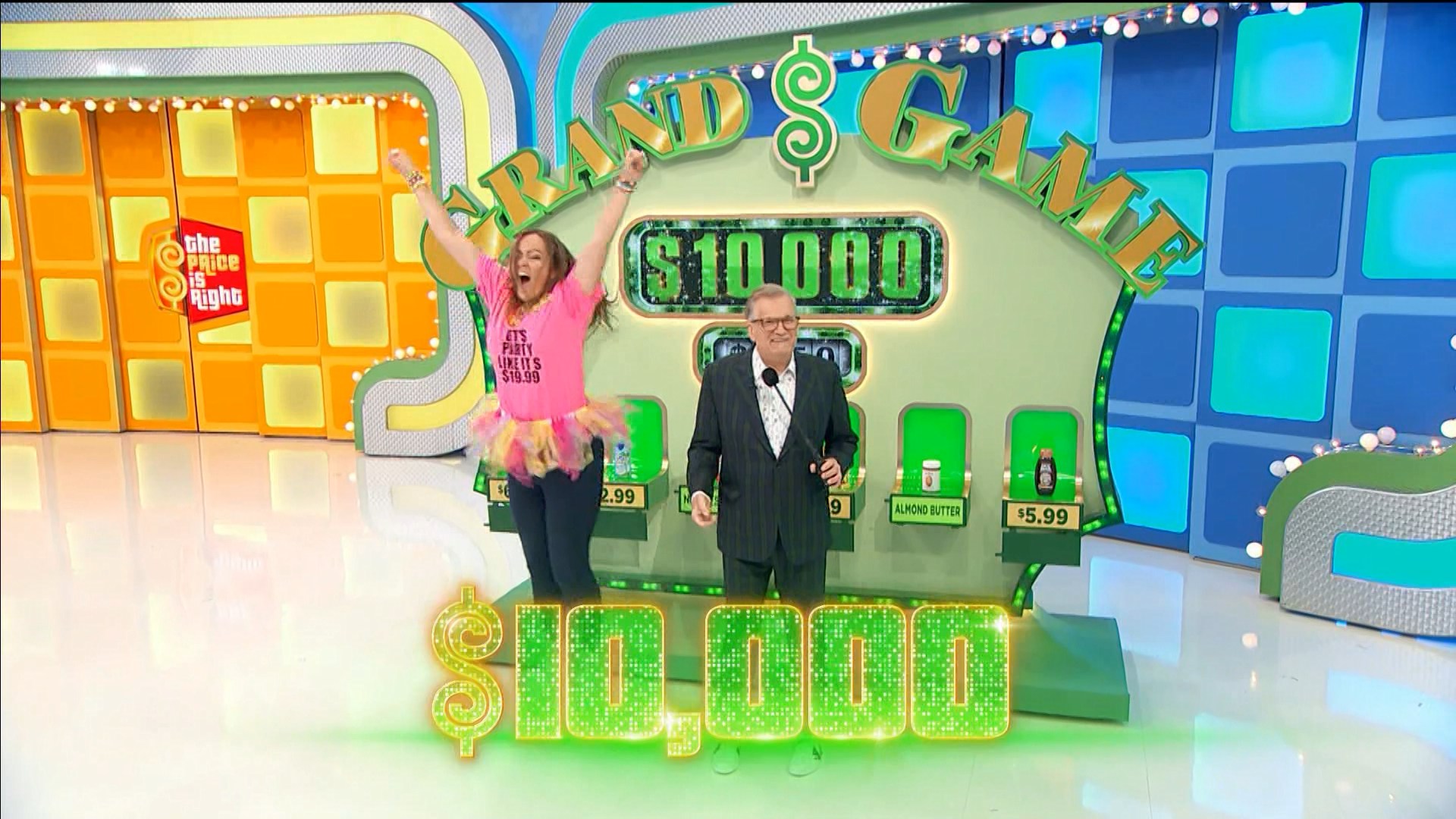 A Price is Right contestant in a pink shirt and tutu reacts with joy at having won ,000 in Grand Game.