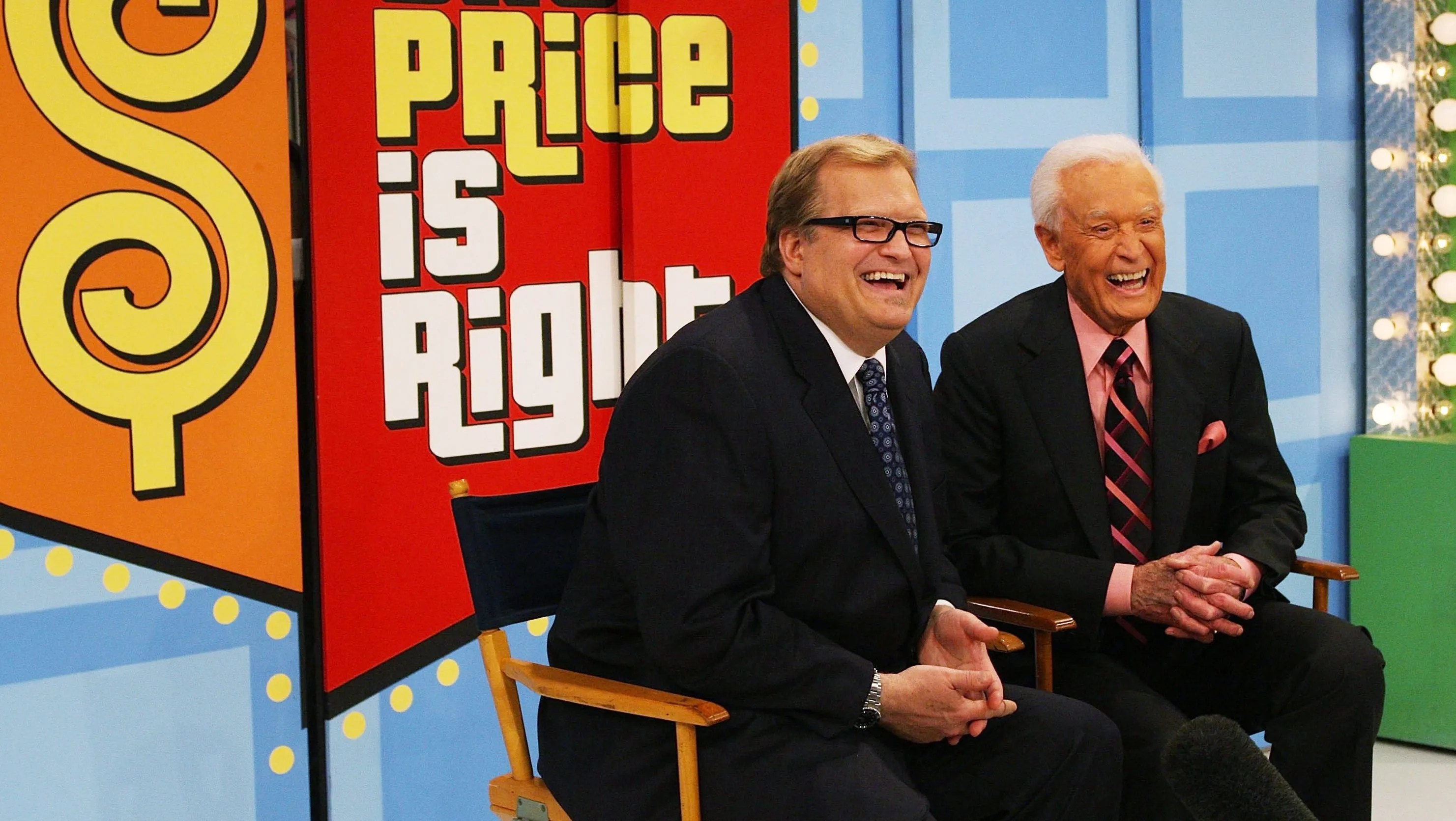 Drew Carey and Bob Barker smiling and laughing together on the set of The Price is Right.