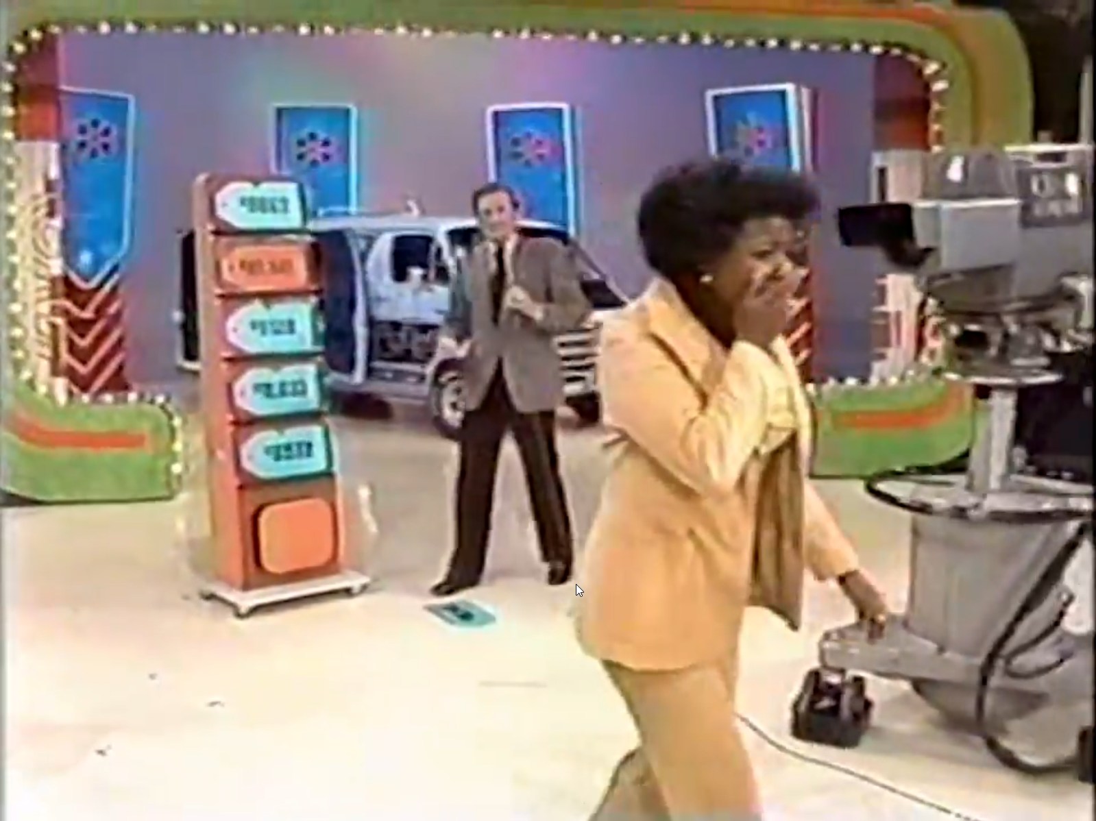 A contestant excitedly reacts as they approach the 'Five Price Tags' game on The Price is Right, with a host in the background.