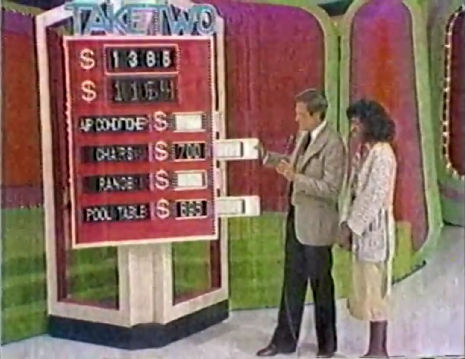 A scene from the game show 'Take Two' featuring a host and a contestant beside a game board displaying the target price of 95 and the prices of four prizes, including an air conditioner, chairs, a range, and a pool table.