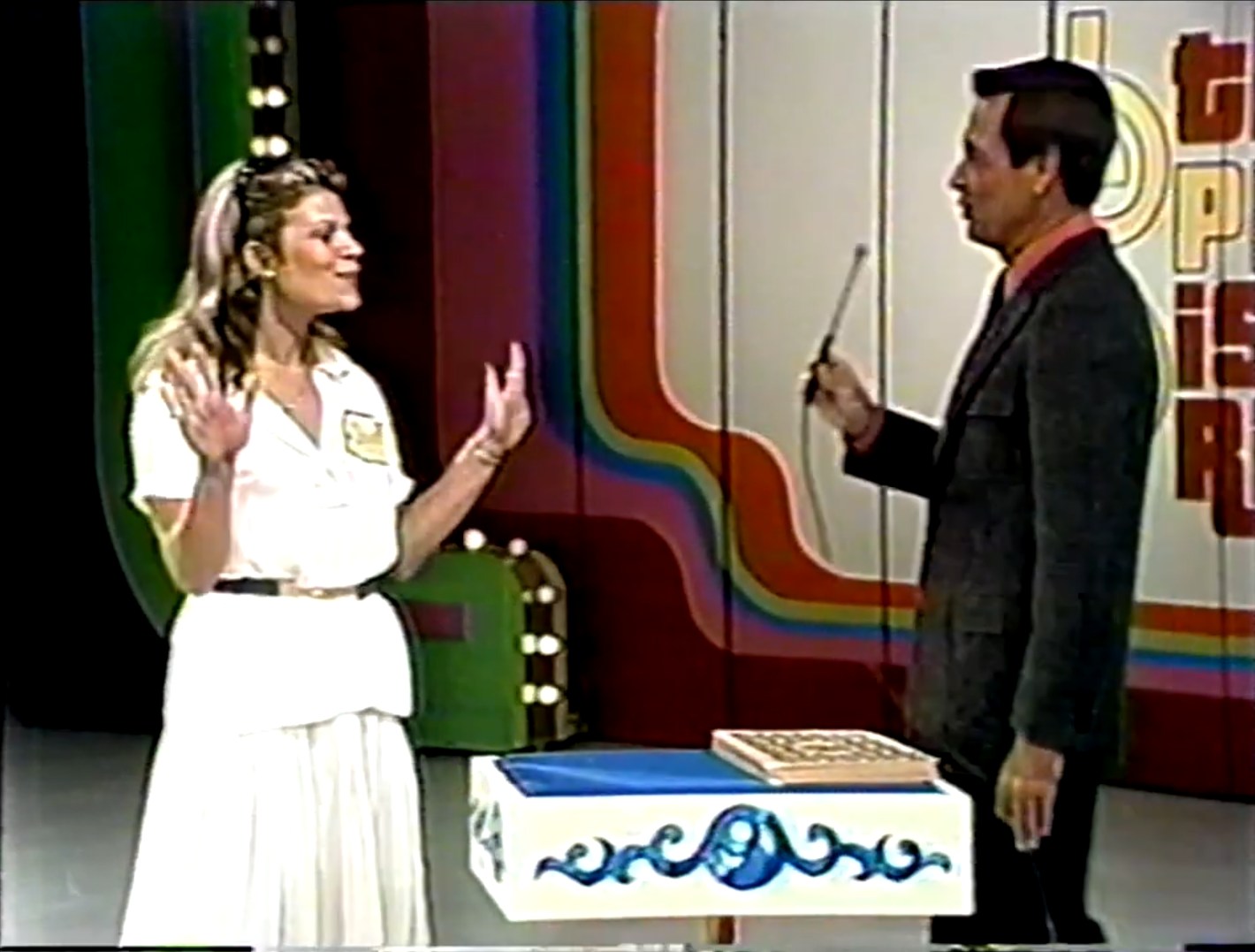 A female contestant expresses excitement while interacting with Bob Barker during a game show segment.