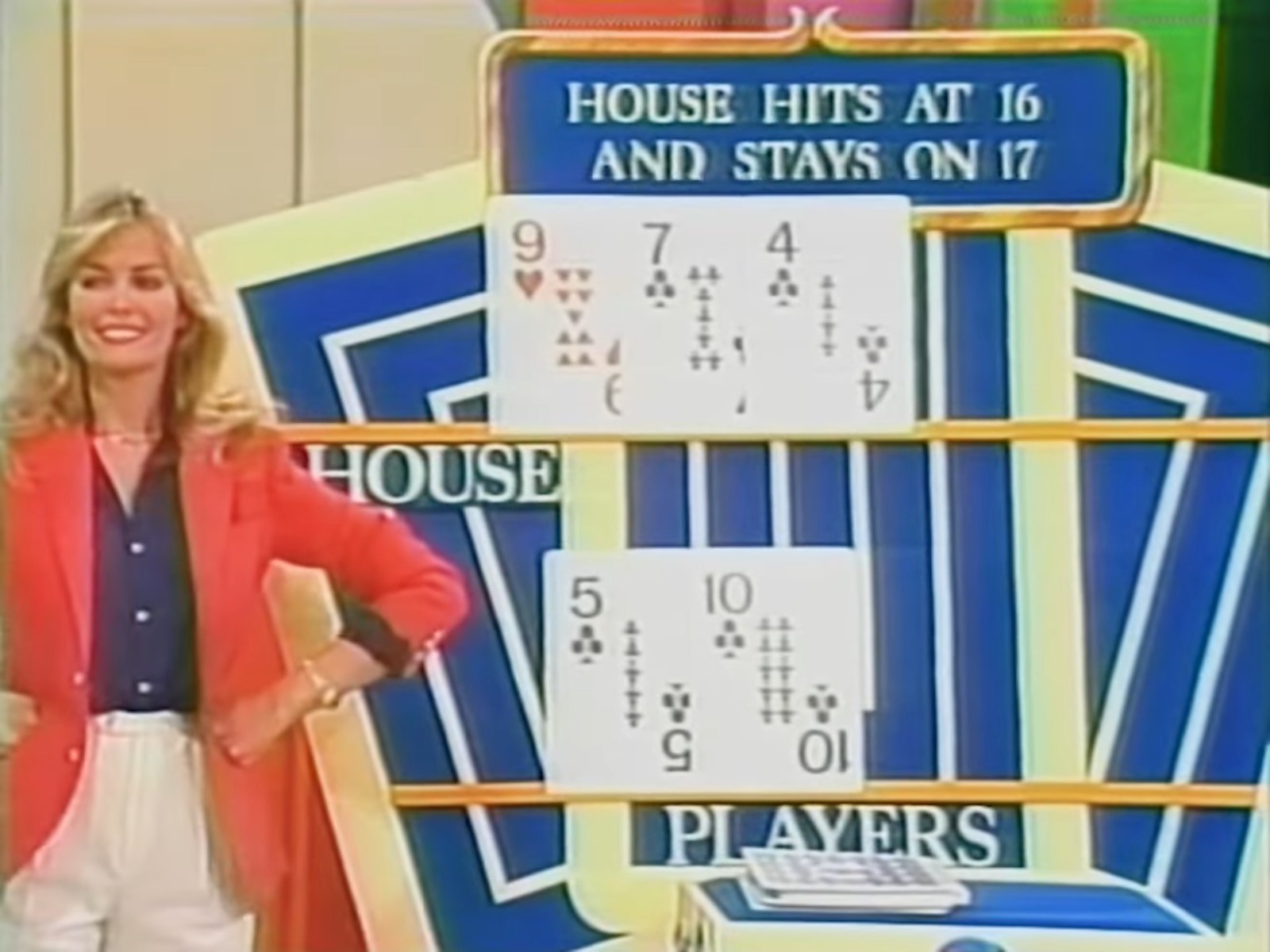 A game show model stands beside a display showing card values in a 'Hit Me' game. The board indicates the house hits at 16 and stays on 17, with visible cards for both the house and the players.