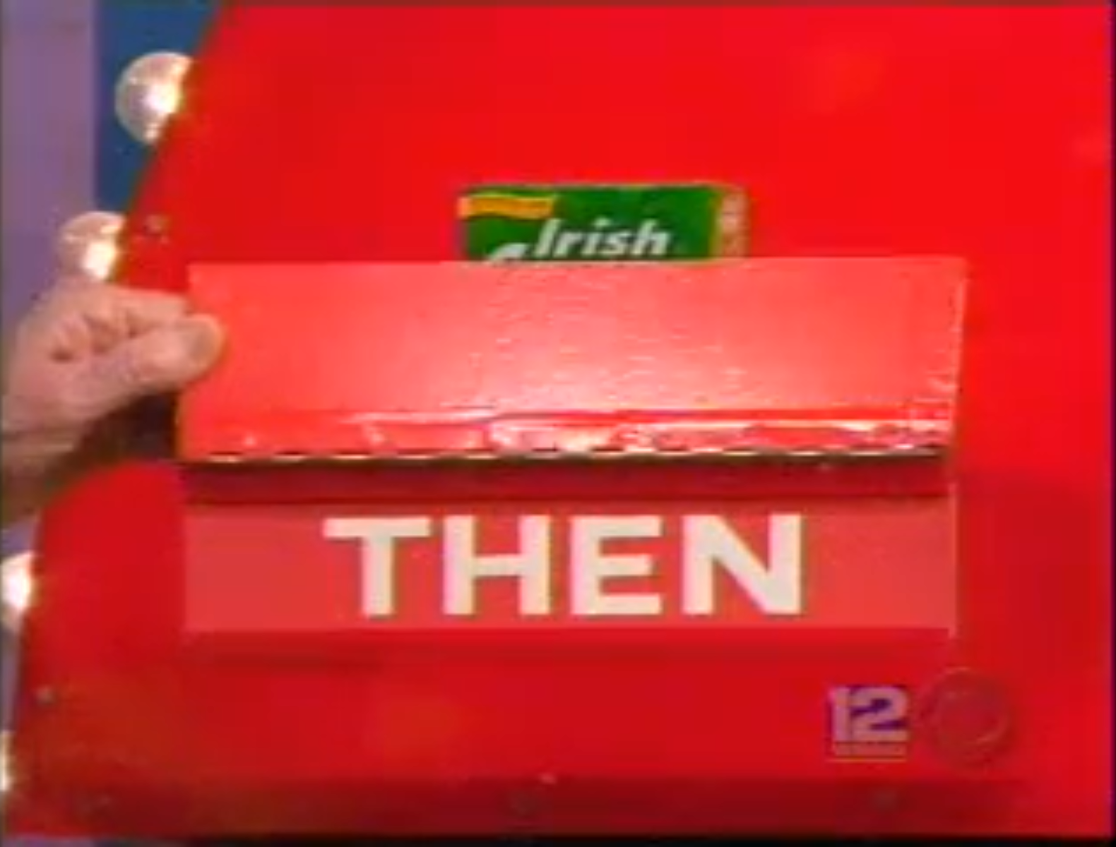 A red and white game board labeled 'THEN', with a hand holding a flap that reveals a product behind it.