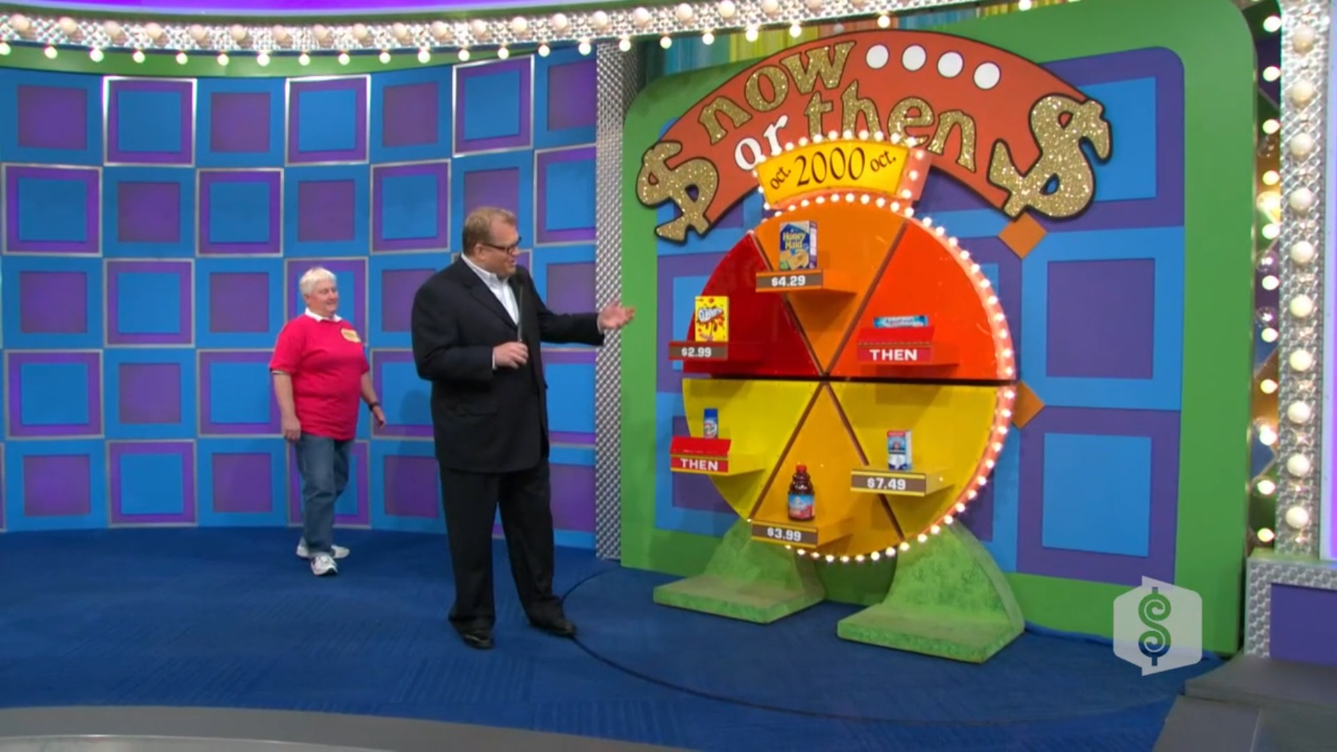 Drew Carey presents the 'Now or Then' pricing game board featuring various grocery products with displayed prices. A contestant approaches while an audience watches in the background.