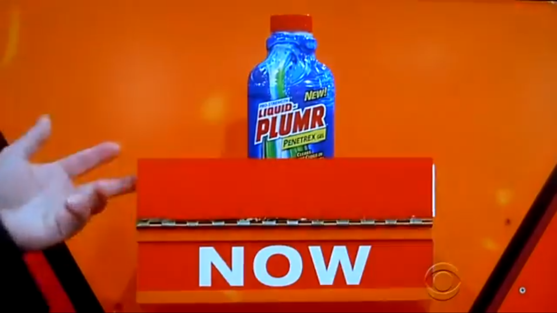 A close-up of a blue bottle of "NEW" Liquid Plumr Penetrex Gel displayed on a game show board with the word 'NOW' prominently visible.