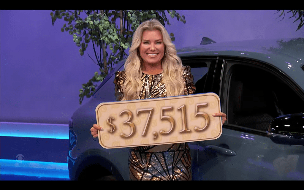 A model smiling and holding a sign that shows the price ,515 next to a vehicle.