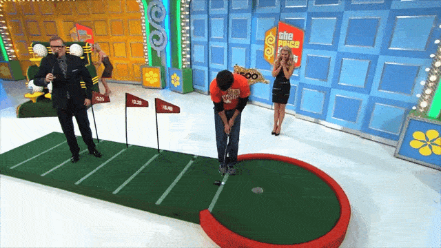 A Price is Right contestant in a Clemson shirt putts a ball into a hole and runs over to the BMW convertible that he's won in the game Hole in One.
