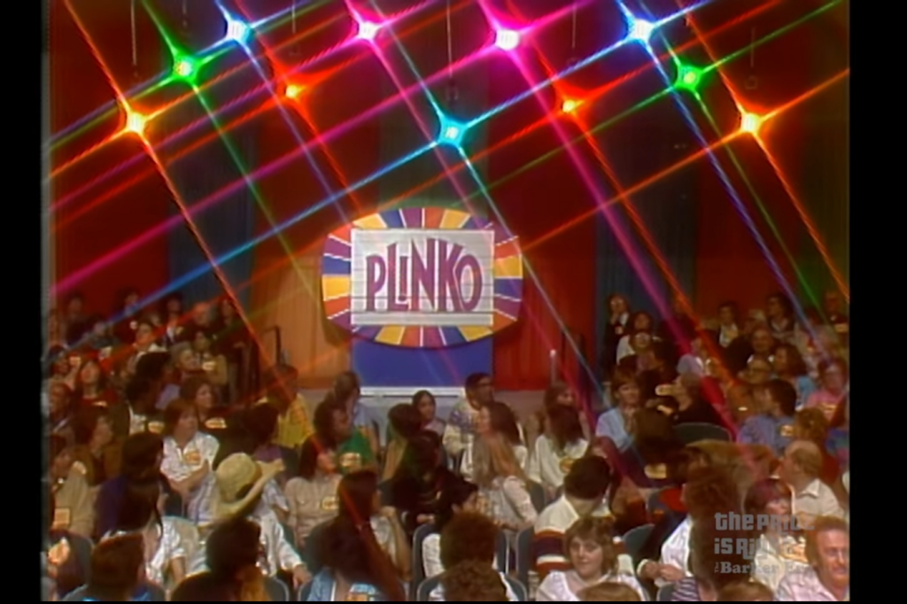 Colorful stage backdrop for the game 'Plinko' from The Price is Right, featuring bright lights and an enthusiastic audience.