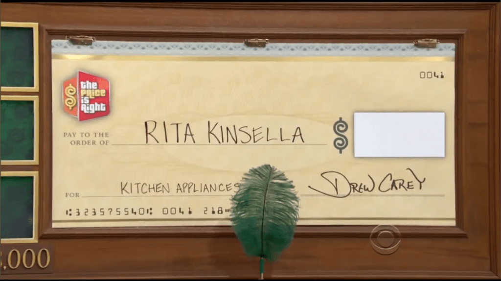A large novelty check from 'The Price is Right' made out to Rita Kinsella for kitchen appliances, signed by Drew Carey.