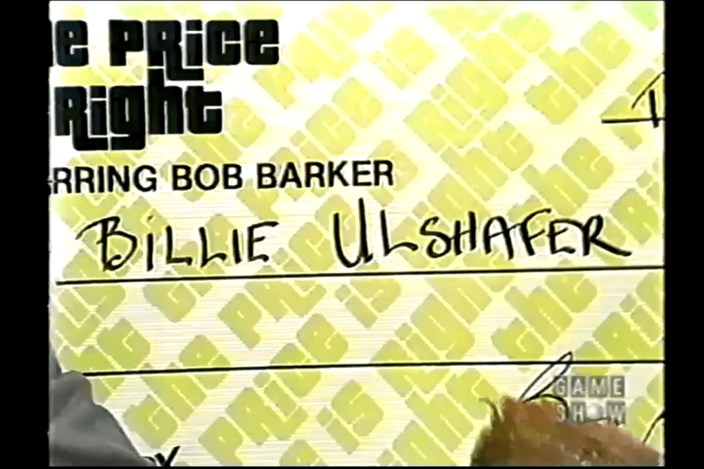 A large novelty check for the contestant Billie Ulshafer on the set of The Price Is Right, featuring the show's logo in the background.