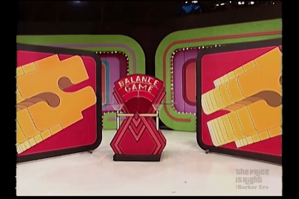Colorful set design for the 1984 Balance Game, featuring a prominent title and large dollar signs on either side.