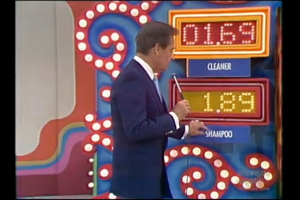 A host points to a display showing prices for 'Cleaner' at .69 and 'Shampoo' at .89 on a colorful set.