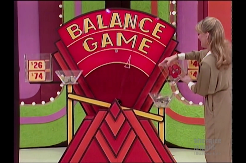A contestant is pouring coins into a bowl on a scale during the Balance Game, with price labels of  and  visible on the side.