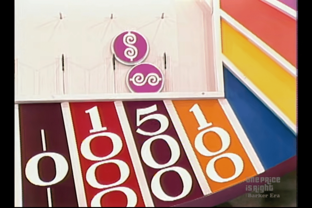 Colorful Plinko board with slots, featuring the game's signature Price is Right dollar sign on two chip in a slot labeled 500.