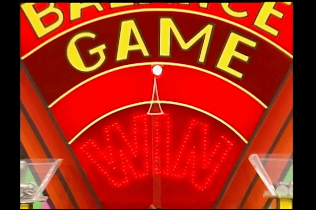 Close-up of the Balance Game display showing the word 'WIN' illuminated in lights against a red background.