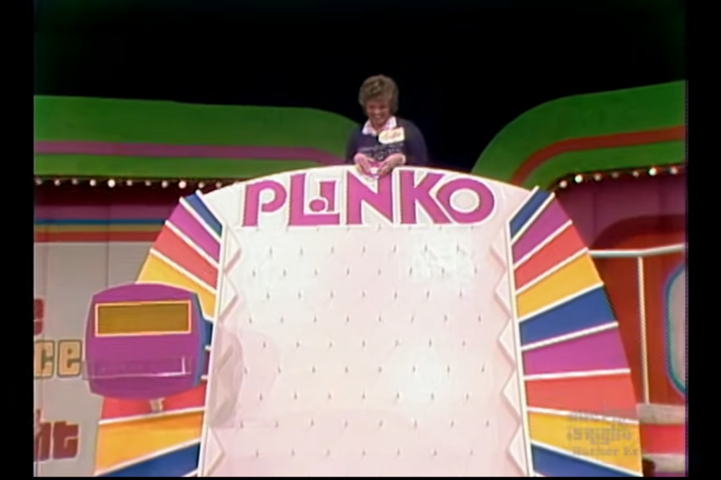 A contestant preparing to drop a Plinko chip onto the colorful Plinko board for the first time, with the game name prominently displayed at the top.