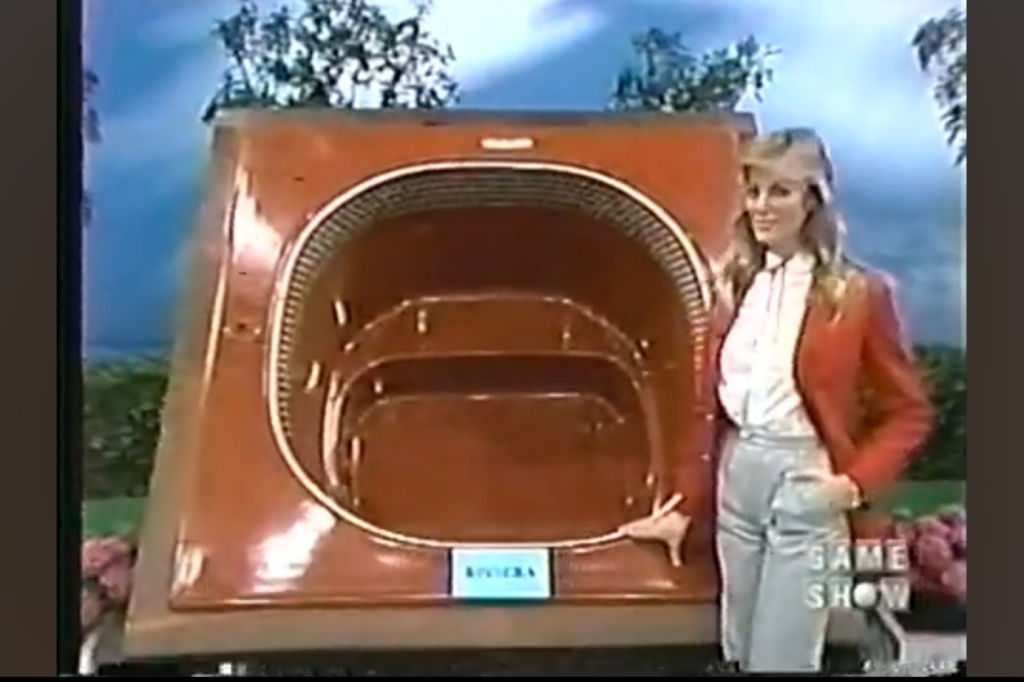 A model stands beside a portable hot tub displayed on The Price is Right, showcasing its features.