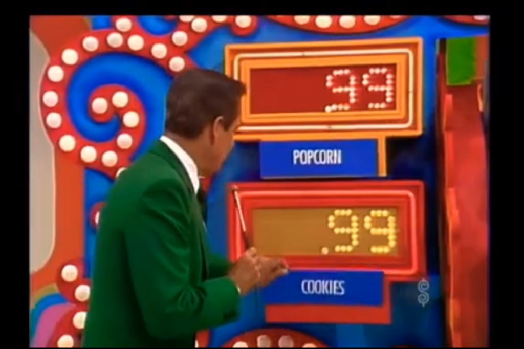 Bob Barker points to two grocery items, popcorn and cookies, both priced at 99 cents, on the colorful 'Pick a Pair' set on The Price is Right.