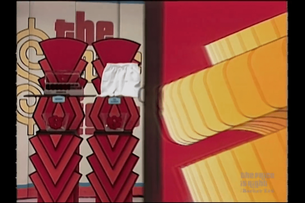 Two prize displays featuring red and black pedestal stands with bowls on top, one displaying a prize covered by a white cloth.