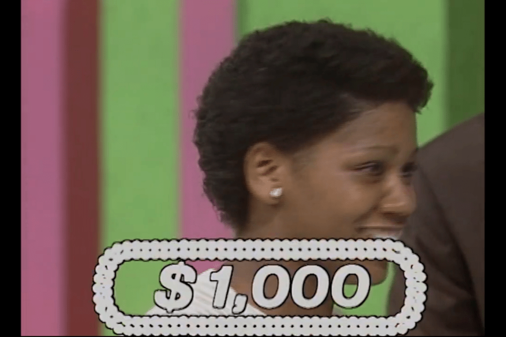 ,000 prize displayed in a game show setting with a contestant smiling.