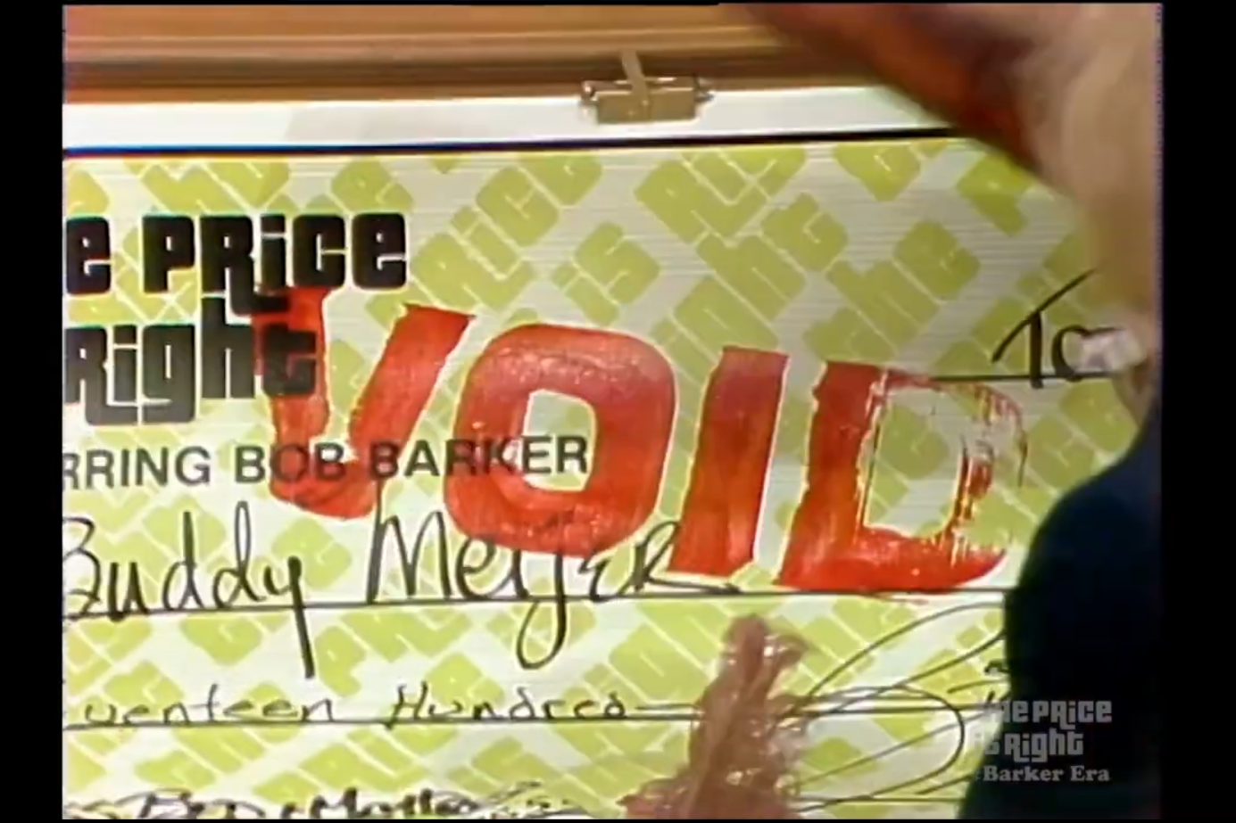 A voided check from 'The Price is Right' game show, prominently featuring the word 'VOID' in red, along with the name 'Buddy Meijer' and other handwritten details.