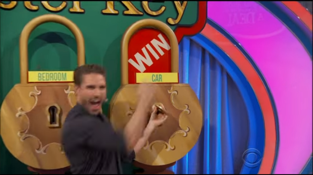 A contestant celebrating next to two large padlocks on a game show set, with labels reading 'BEDROOM' and 'WIN'.