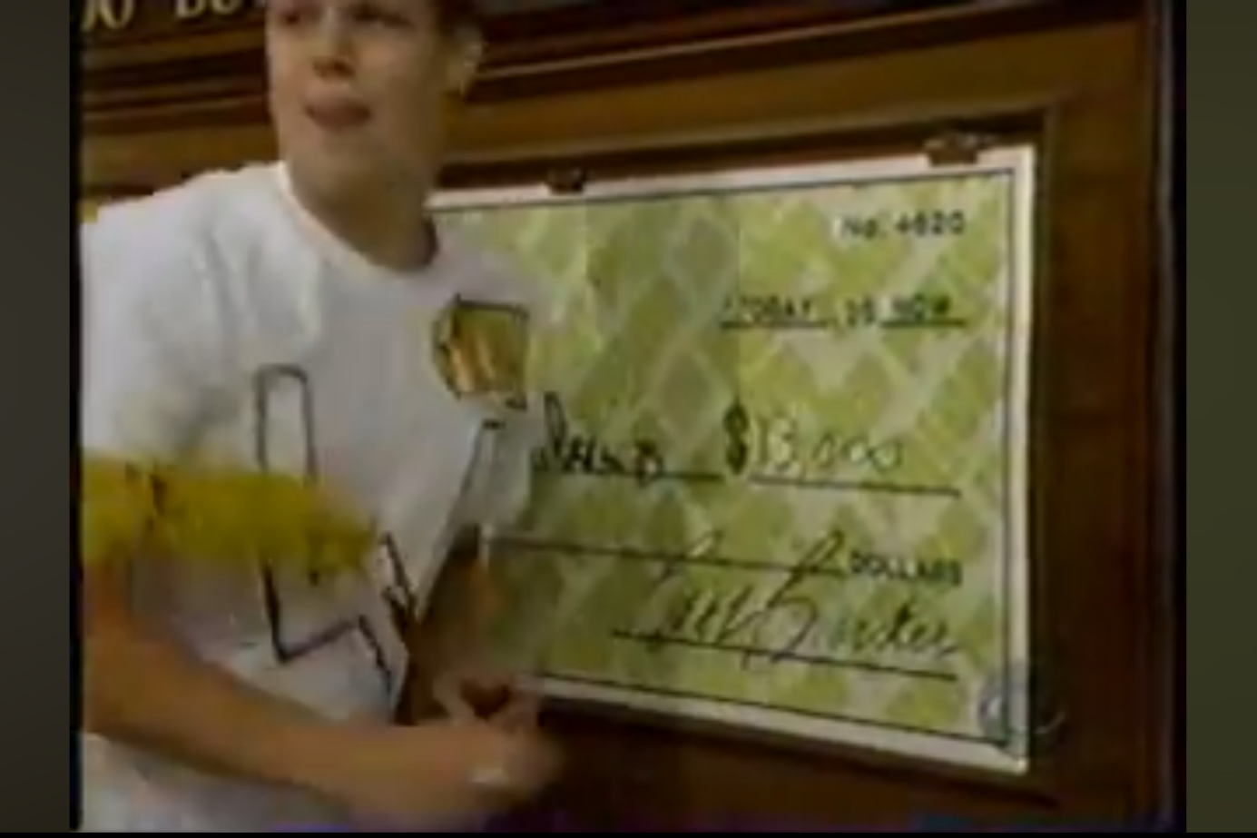 A contestant holding a large novelty check for ,000 in the game Check Game on The Price is Right.