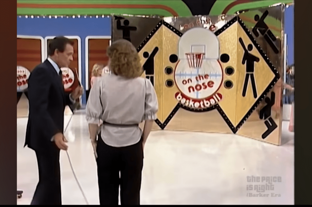 Contestant prepares to play On the Nose, a basketball-themed game on The Price is Right, with host and game backdrop visible.