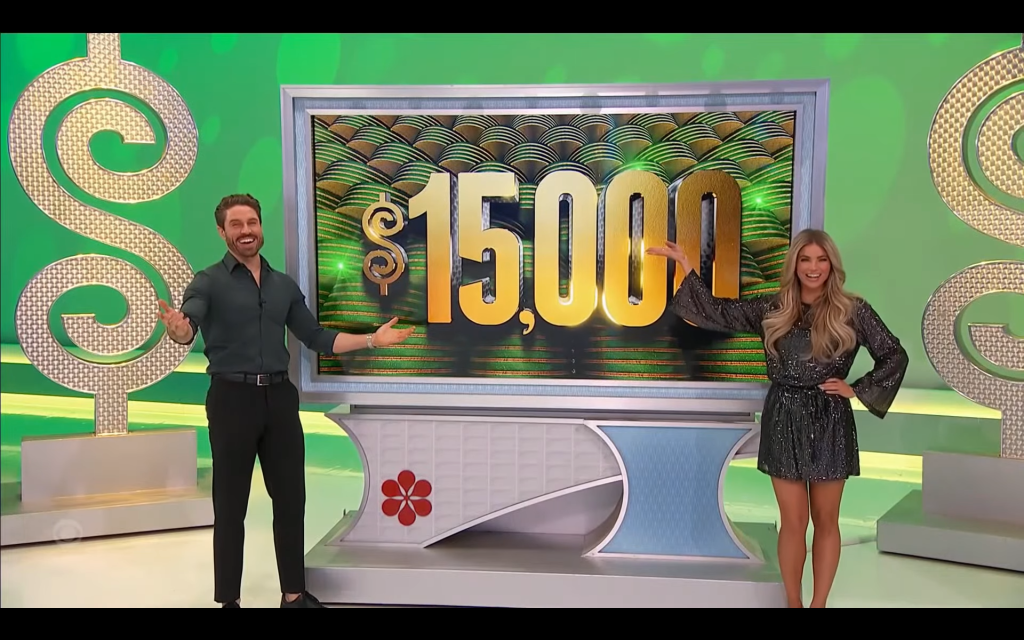Models celebrate in front of a large display featuring the prize amount of ,000 on The Price is Right set.