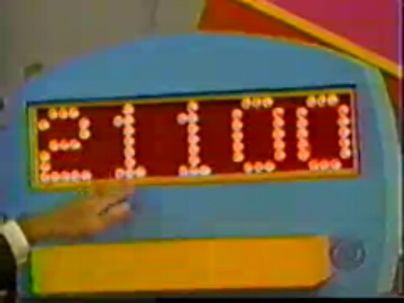 A colorful game board display showing a total cash amount of ,100, with a hand pointing at the numbers.