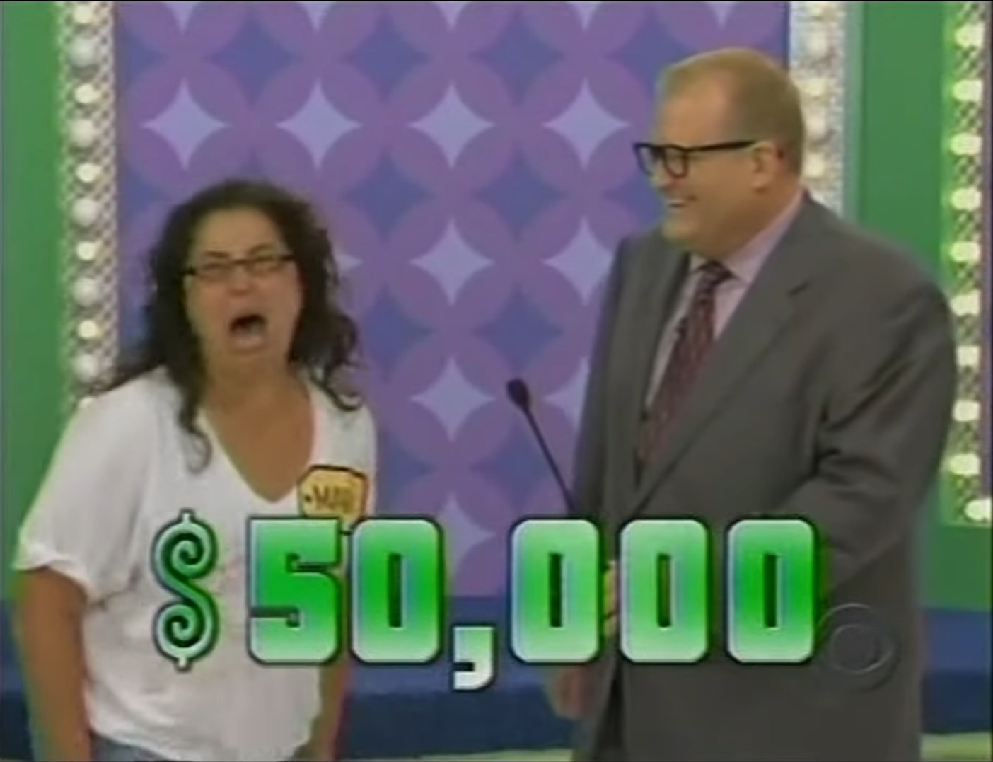 A contestant on The Price is Right celebrates after being told they can win ,000, standing next to the host with a joyful expression, needing to use the rest room