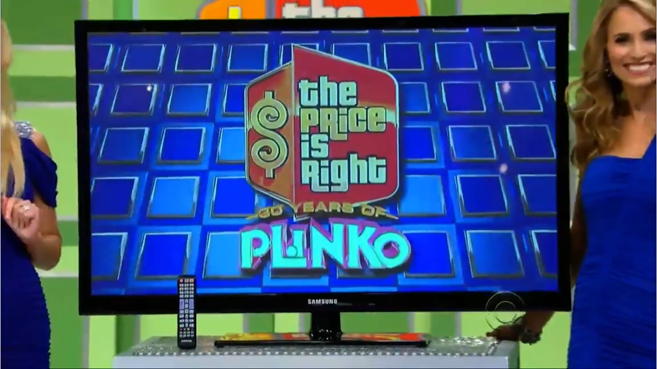 A promotional display for the 30th Anniversary of Plinko on The Price is Right, featuring the show's logo and vibrant blue background, with a smiling contestant beside it.