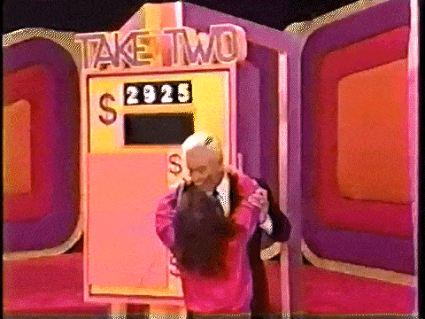 Bob Barker getting mobbed by an enthusiastic contestant.