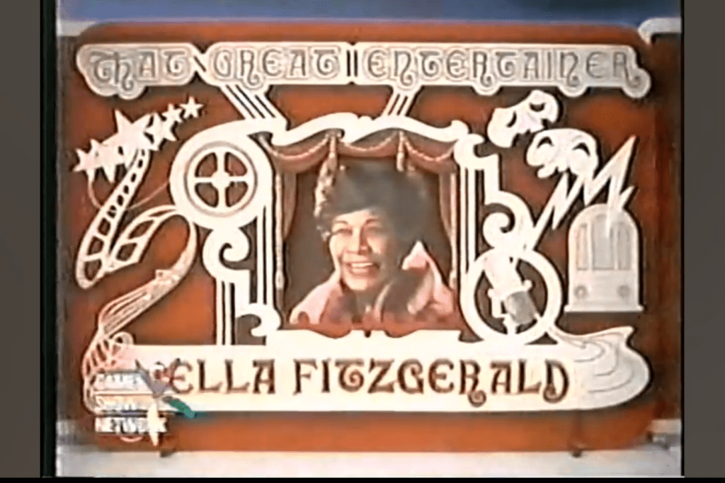 A colorful tribute graphic featuring the name 'Ella Fitzgerald' surrounded by musical and cinematic motifs, emphasizing her status as a renowned entertainer.