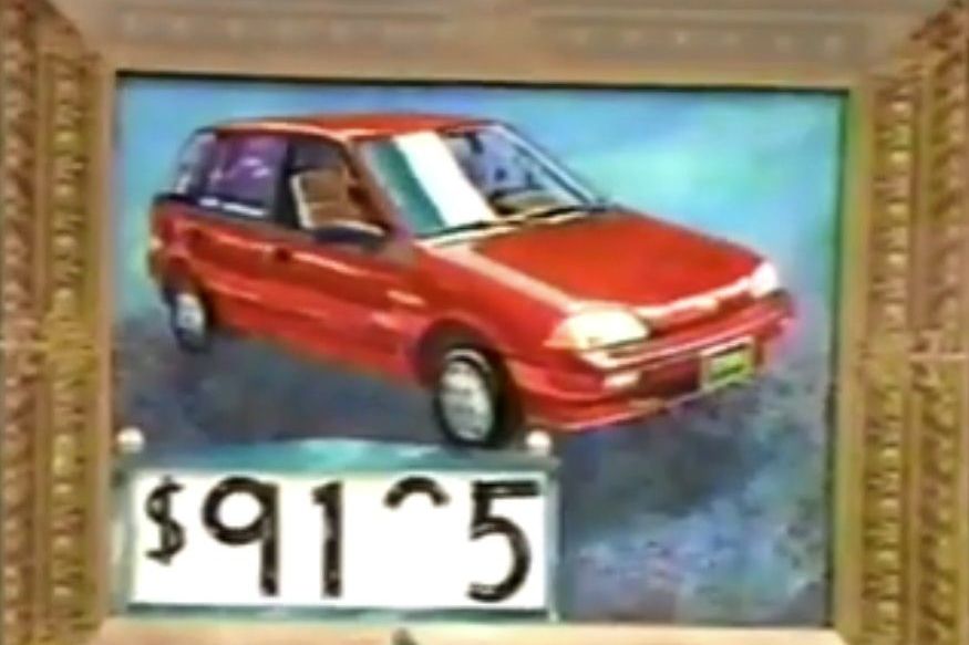 A painting of a red hatchback car displayed in a decorative frame with a price tag showing _5, with the third digit missing.