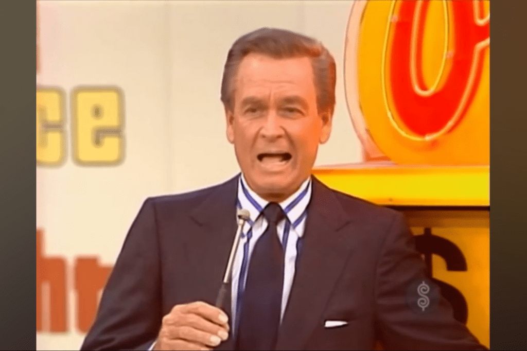 Bob Barker hosting a game show segment, holding a microphone and speaking energetically in front of a colorful background.