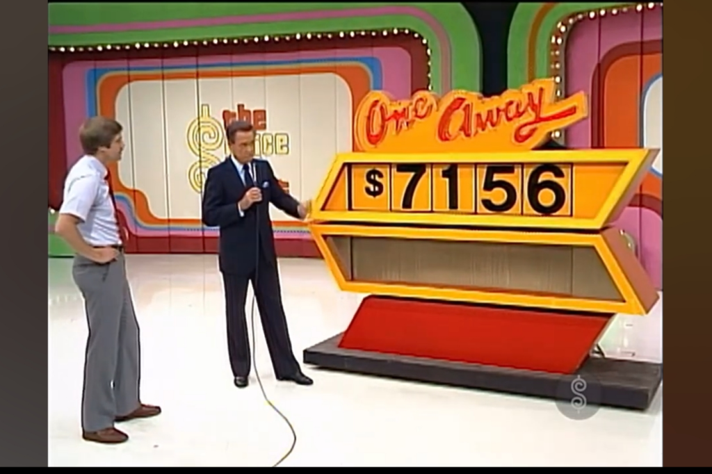 A host stands beside a pricing game called 'One Away' with a contestant looking on, displaying the incorrect car price of ,156.