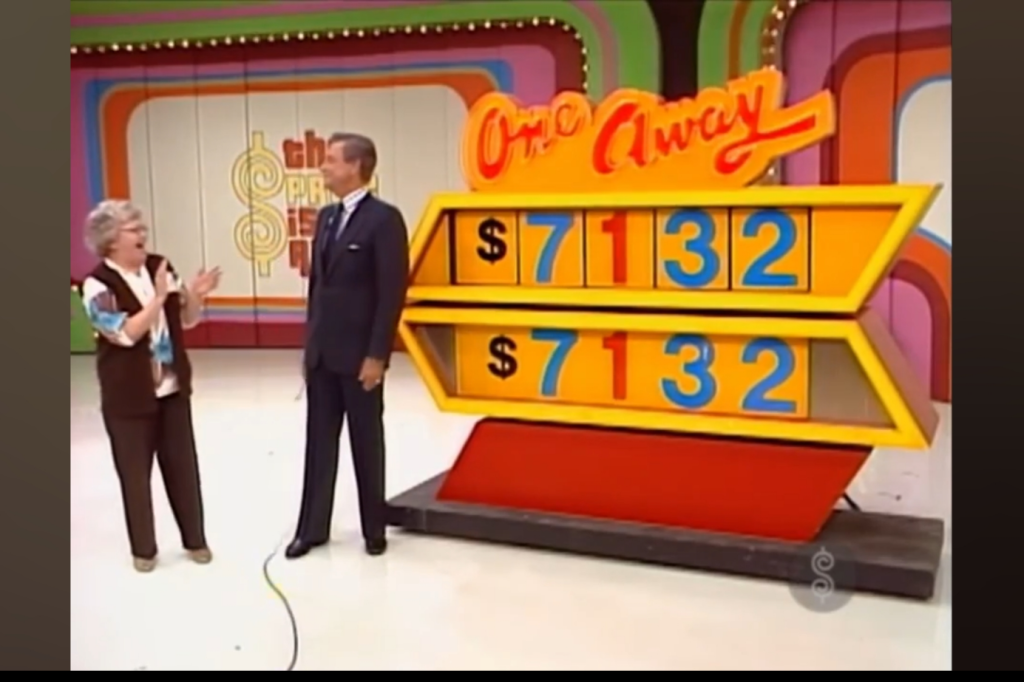A contestant celebrating with Bob Barker on 'The Price is Right' during the One Away game, showcasing the digits 7, 1, 3, 2 on the game board.