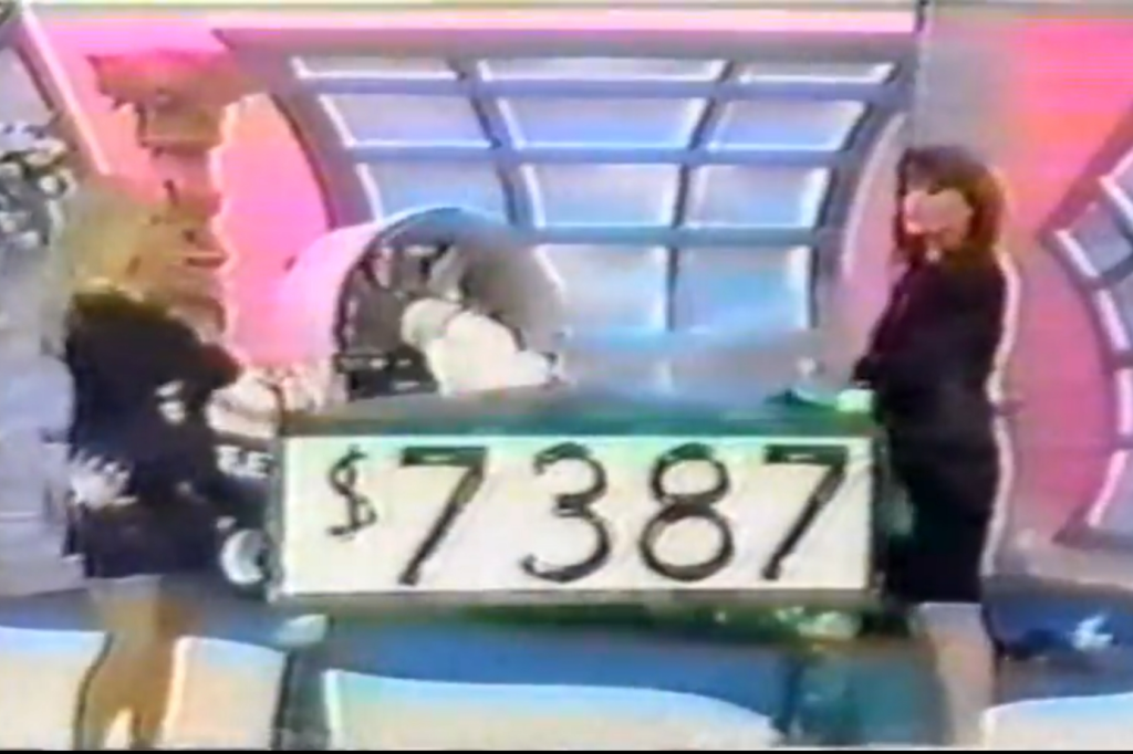 Two models on a game show are celebrating while presenting a large sign that displays the amount ,387.