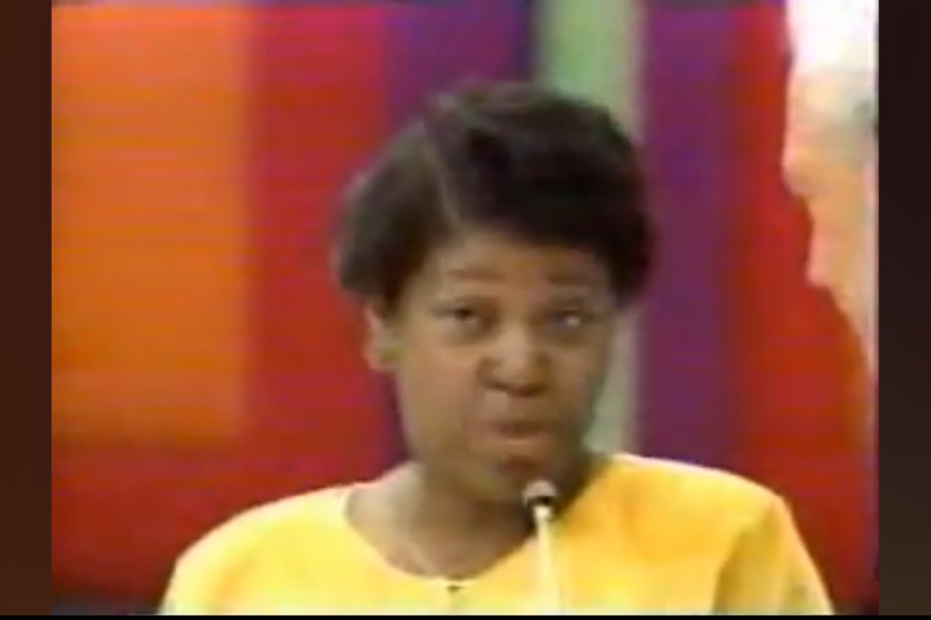 A contestant speaking during the One Away game segment on The Price is Right, wearing a yellow shirt and microphone in front of colorful backdrop.