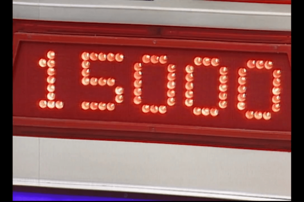 A digital display showing the prize amount of ,000 in bright red lights, typical of game show decor.