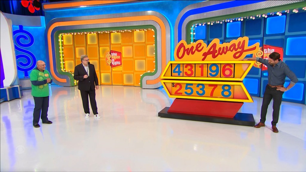 Contestants participating in the One Away game on The Price is Right, with a colorful game board displaying numbers.
