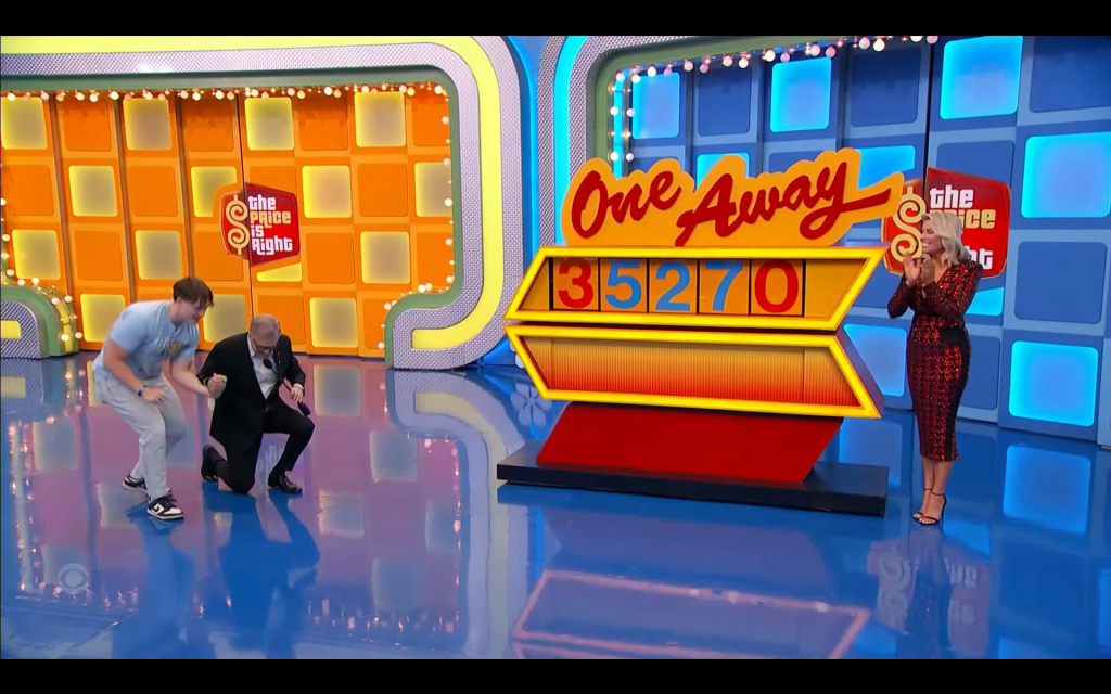A contestant and the host celebrate during the game 'One Away' on 'The Price is Right,' with the displayed numbers showing 3, 5, 2, 7, and 0.