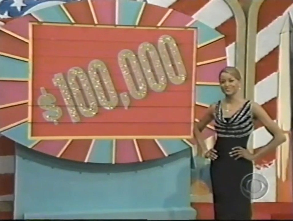 A model stands confidently beside a game display featuring the prize of 0,000 on The Price is Right, with a vibrant background.