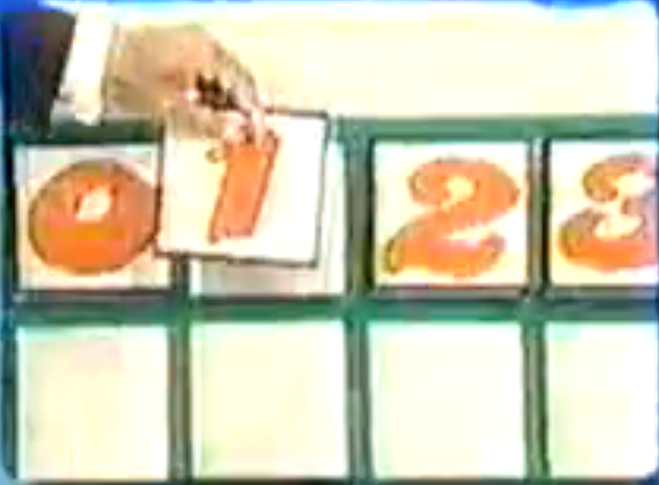 A contestant picks the digit '1' from a board displaying numbers 0-9 in an addition game.