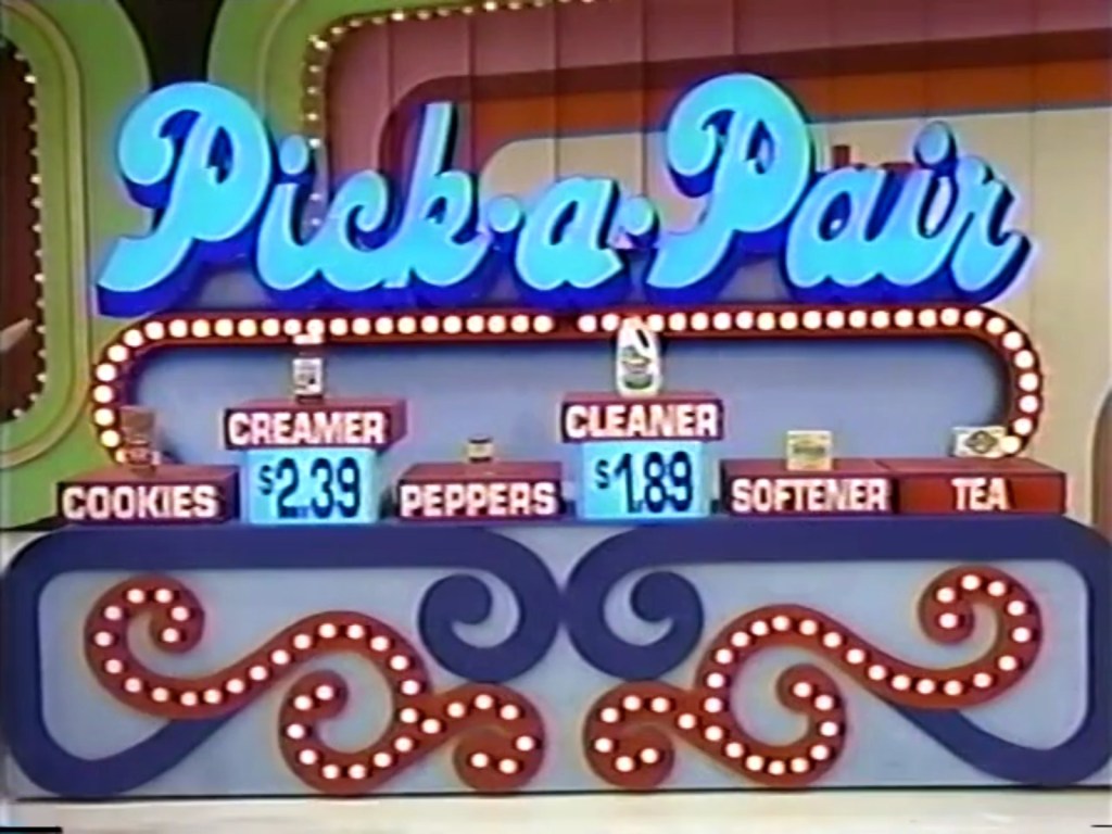 Display board for a pricing game on The Price is Right titled 'Pick-a-Pair' featuring items and their prices, including cookies, creamer, peppers, cleaner, softener, and tea.