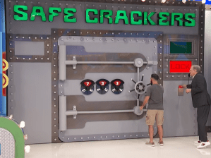 Contestant interacting with the 'Safe Crackers' game on The Price is Right, featuring a large safe with a combination lock and bright signage.